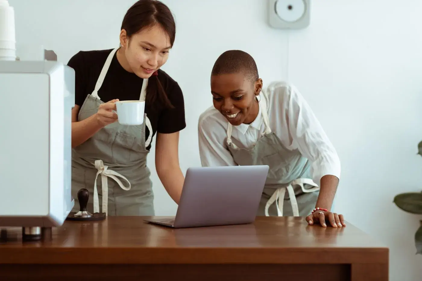 Two café workers looking at a laptop together